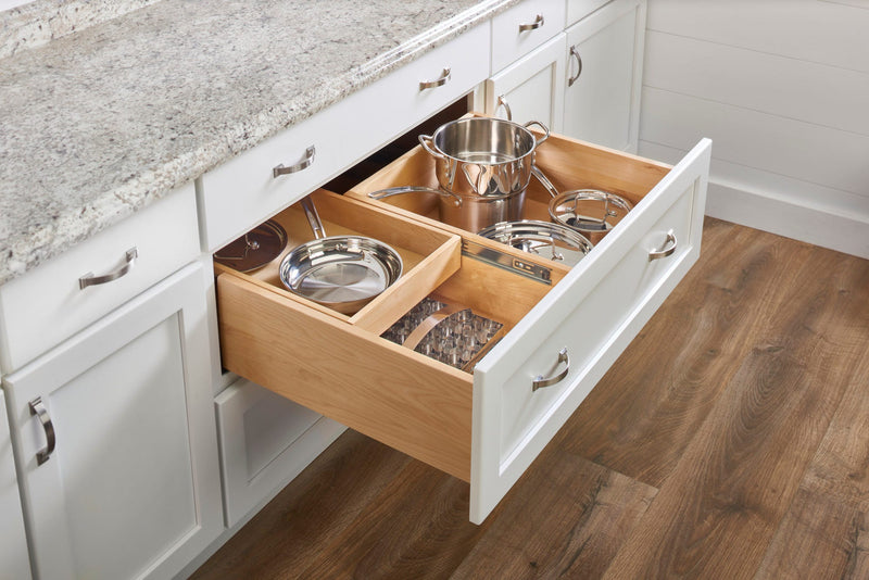Deep tiered drawer organizer with pots and pans in a white kitchen base cabinet