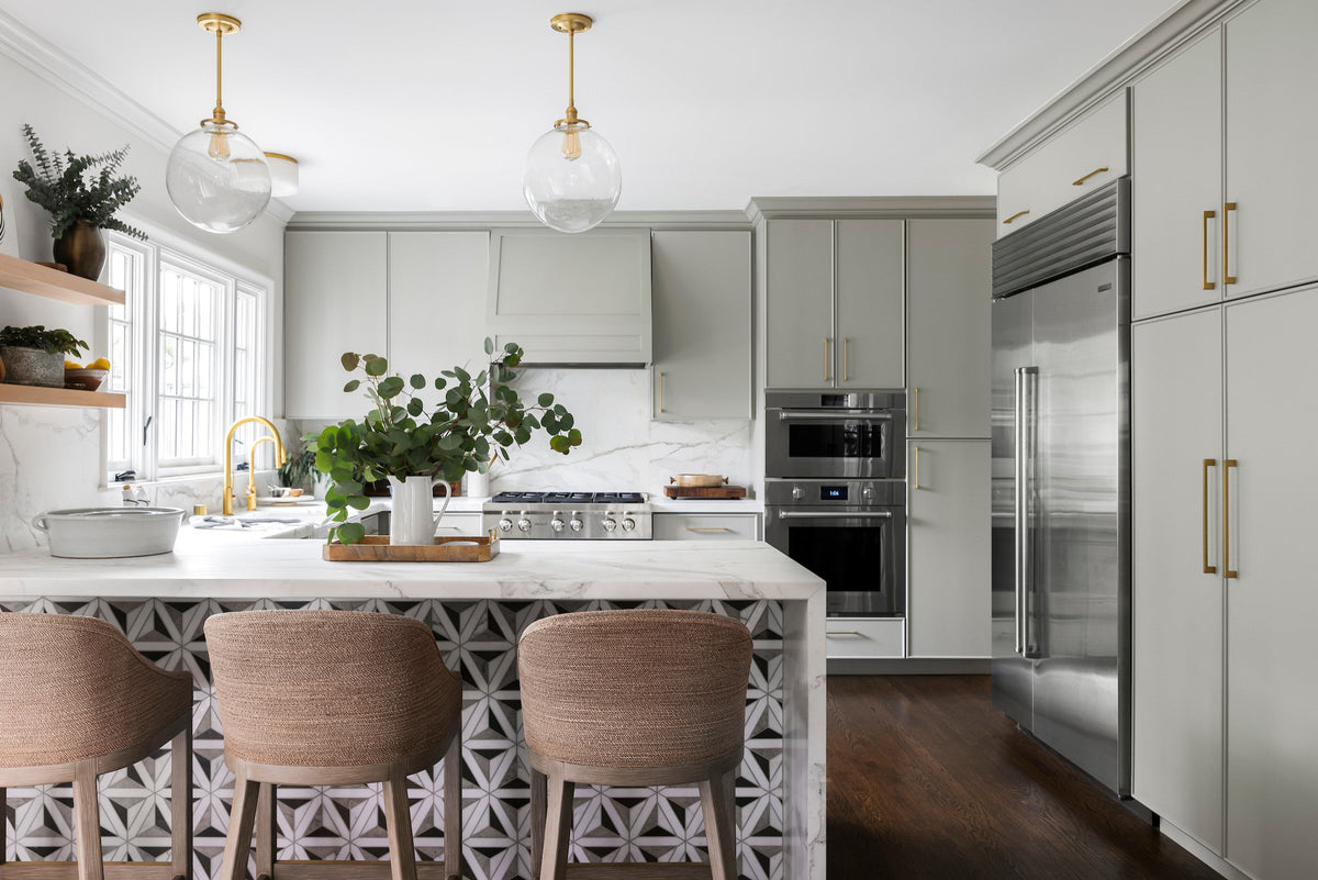 Semi-custom kitchen with sage cabinetry and waterfall peninsula