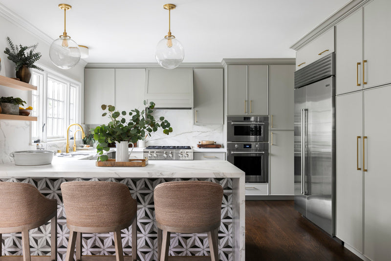 Semi-custom kitchen with sage cabinetry and waterfall peninsula